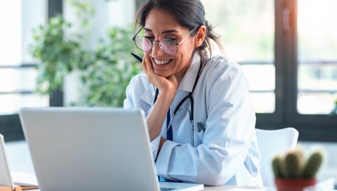 A veterinary professional working on the laptop